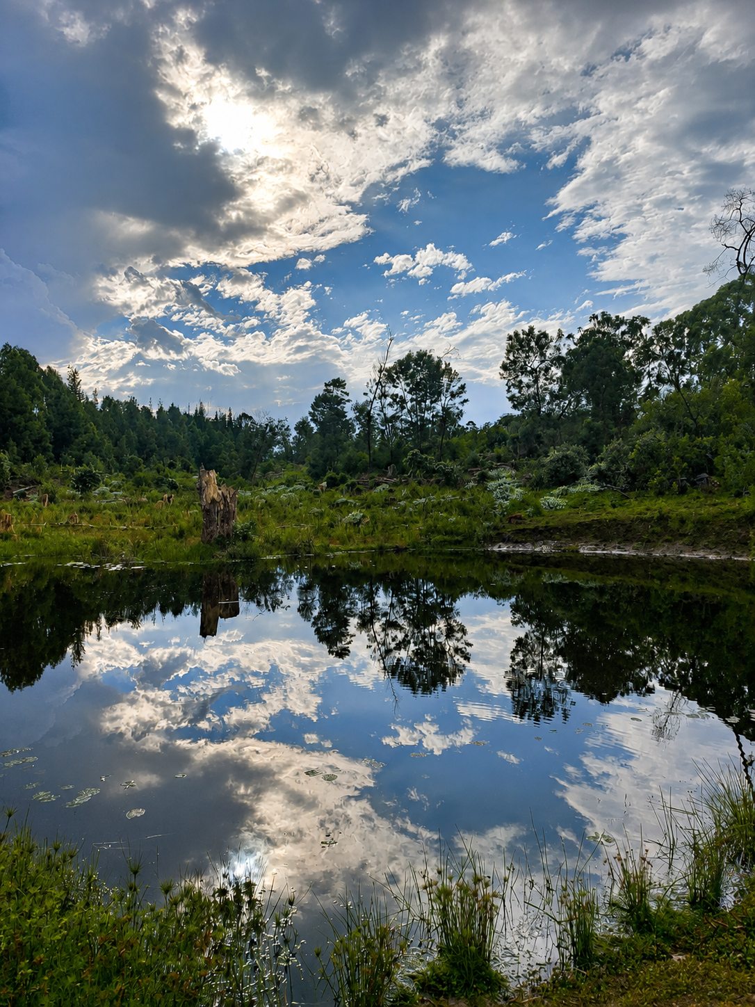 The dam mirroring a dramatic sky, the cabin beyond